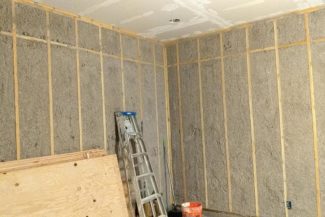 All that blown insulation settled into its spaces. Drywall installed on the ceiling. Plywood acclimating so it can be ready to sheet the walls once the ceiling is complete.