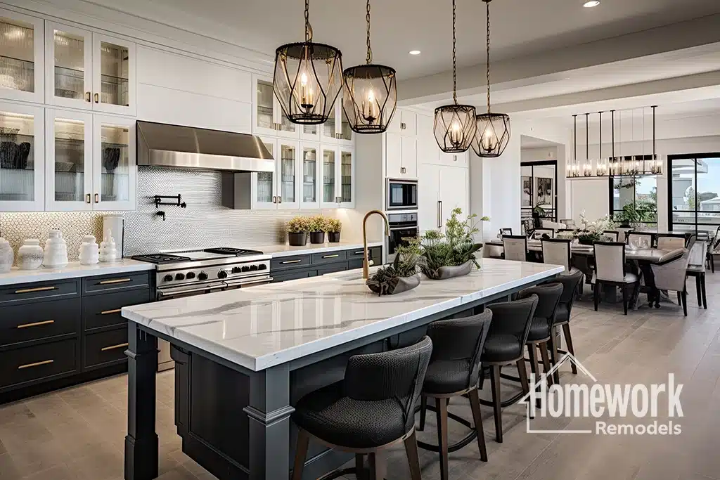 Modern kitchen in Phoenix, AZ, featuring a large marble island, black chairs, pendant lights, stainless steel appliances, white cabinets, and an open dining area in the background. Homework Remodels logo is in the bottom right corner.