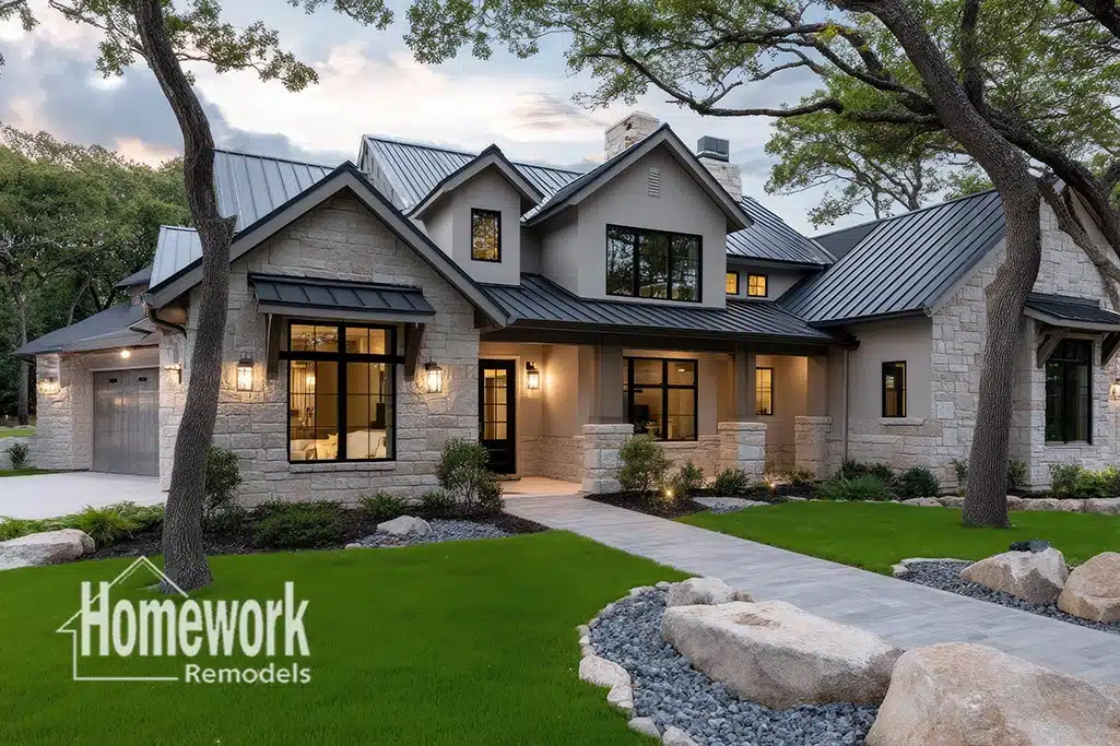 A modern two-story house with stone and stucco exterior, black metal roof, large windows, and Homework Remodels logo in the corner. Nestled in Central Phoenix’s Arcadia Lite, it showcases whole-home remodeling amid mature trees and a manicured lawn.
