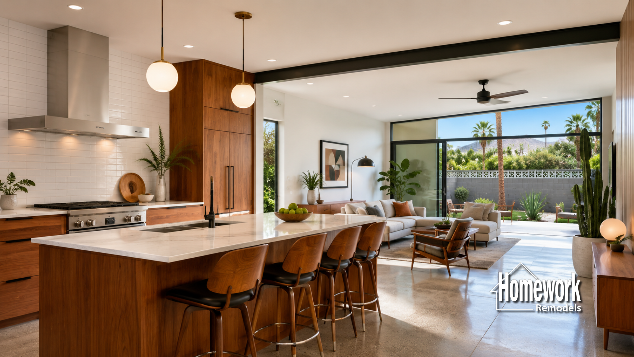 A modern open-concept kitchen and living area in Mesa features wood cabinets, a large island with stools, and sliding glass doors leading to a sunny patio with palm trees—perfect for better flow than older floor plans. Homework Remodels logo is in the lower right corner.
