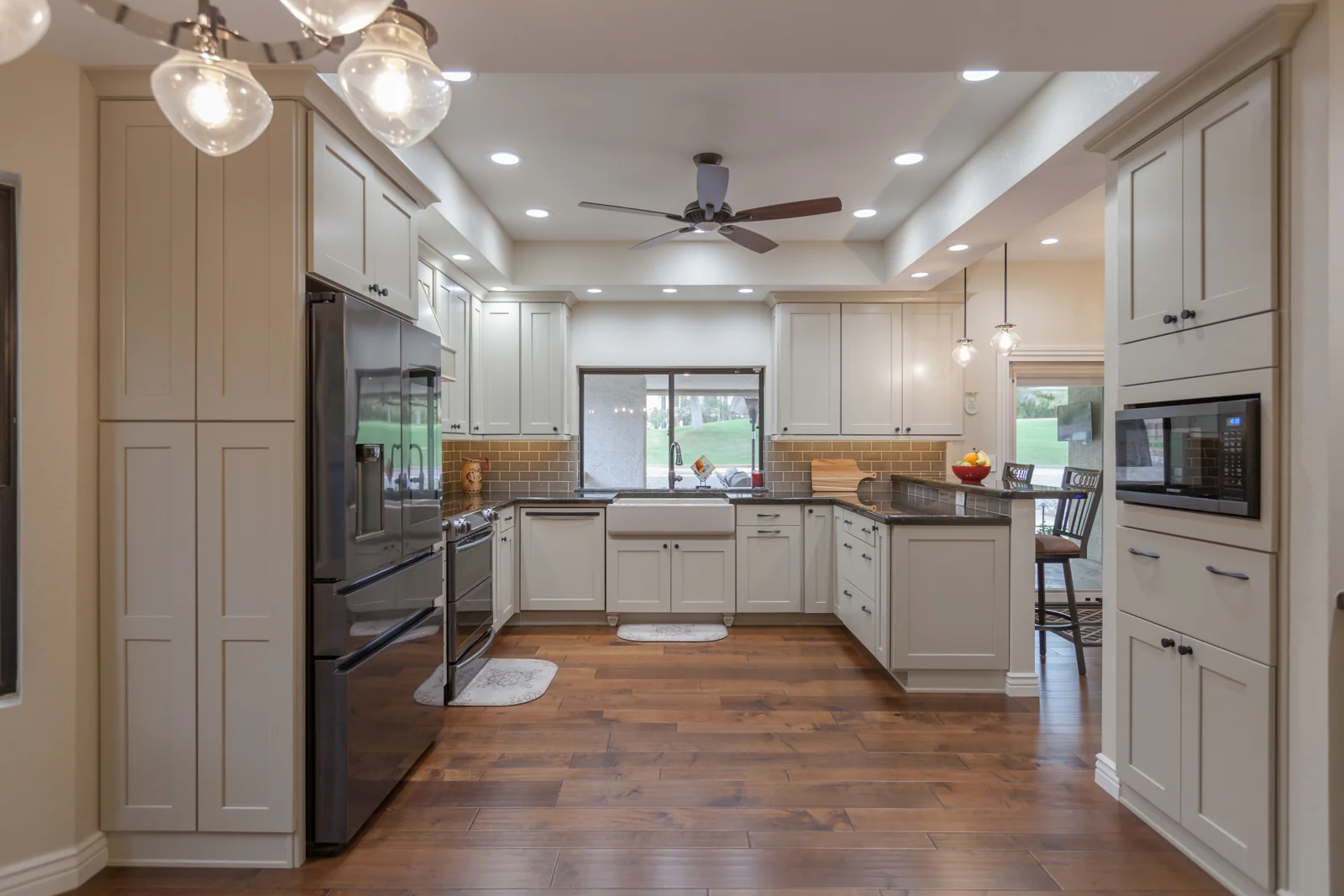 Updated Biltmore kitchen with warm gray cabinets, granite counters, an apron-front sink, and pendant lighting