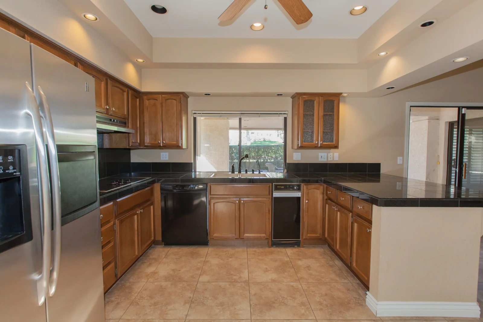 Biltmore kitchen before remodeling with wood cabinets, a low soffit, and dark countertops