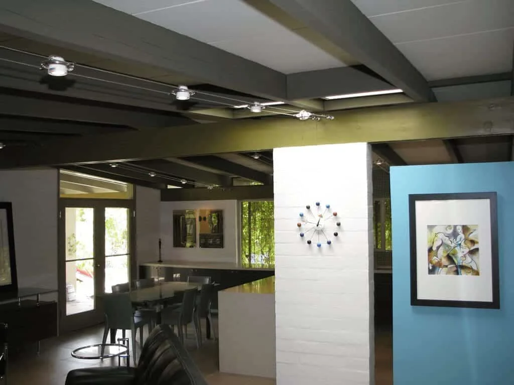 Exposed ceiling beams and cable lighting above the dining and living spaces