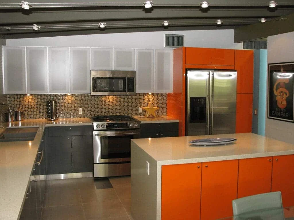 Orange refrigerator surround, gray lower cabinetry, and frosted-glass upper kitchen cabinets