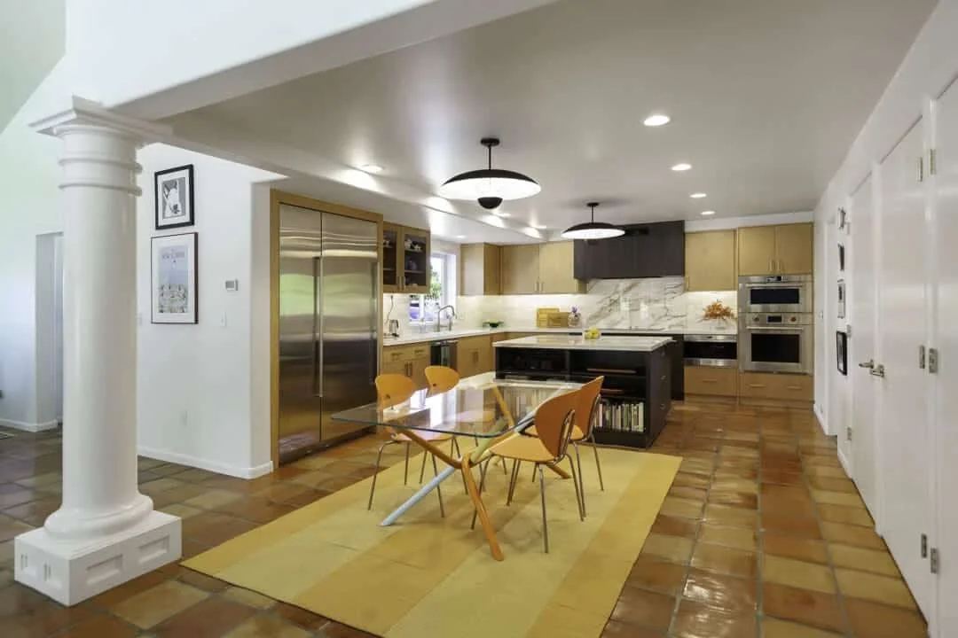 Custom kitchen remodel in Mesa Arizona with natural wood cabinets, a dark island and hood, veined porcelain surfaces, and an adjoining dining area