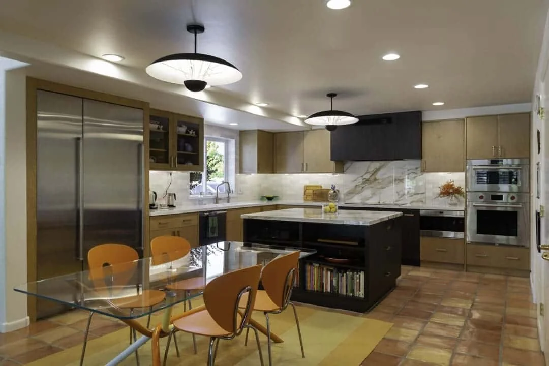 Mesa kitchen with stainless steel refrigerator and freezer columns, natural wood cabinetry, a dark island, and a nearby glass dining table