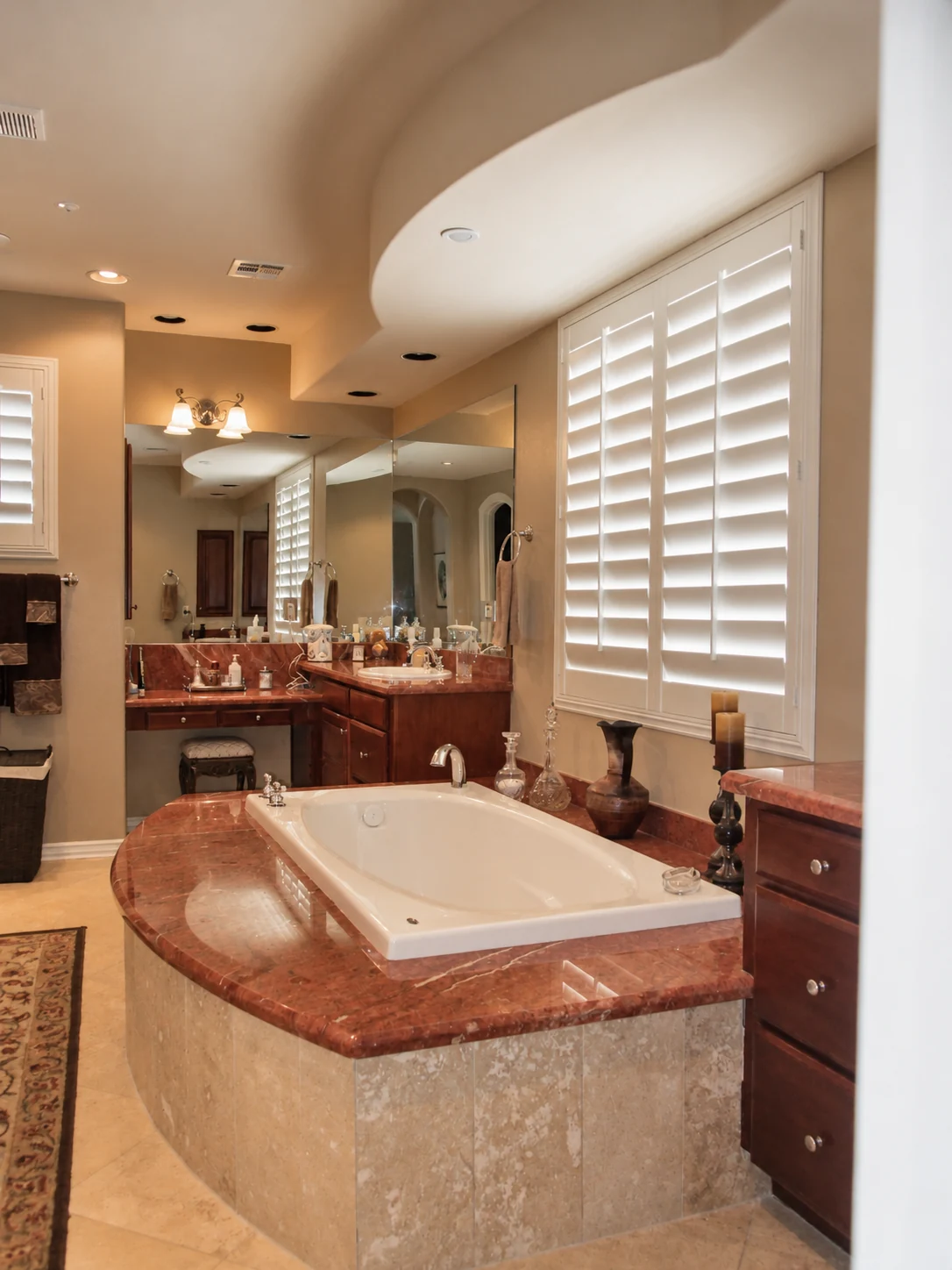 Original bathroom before remodeling with a large built-in tub deck, broad mirrors, and limited vanity storage; exposure corrected