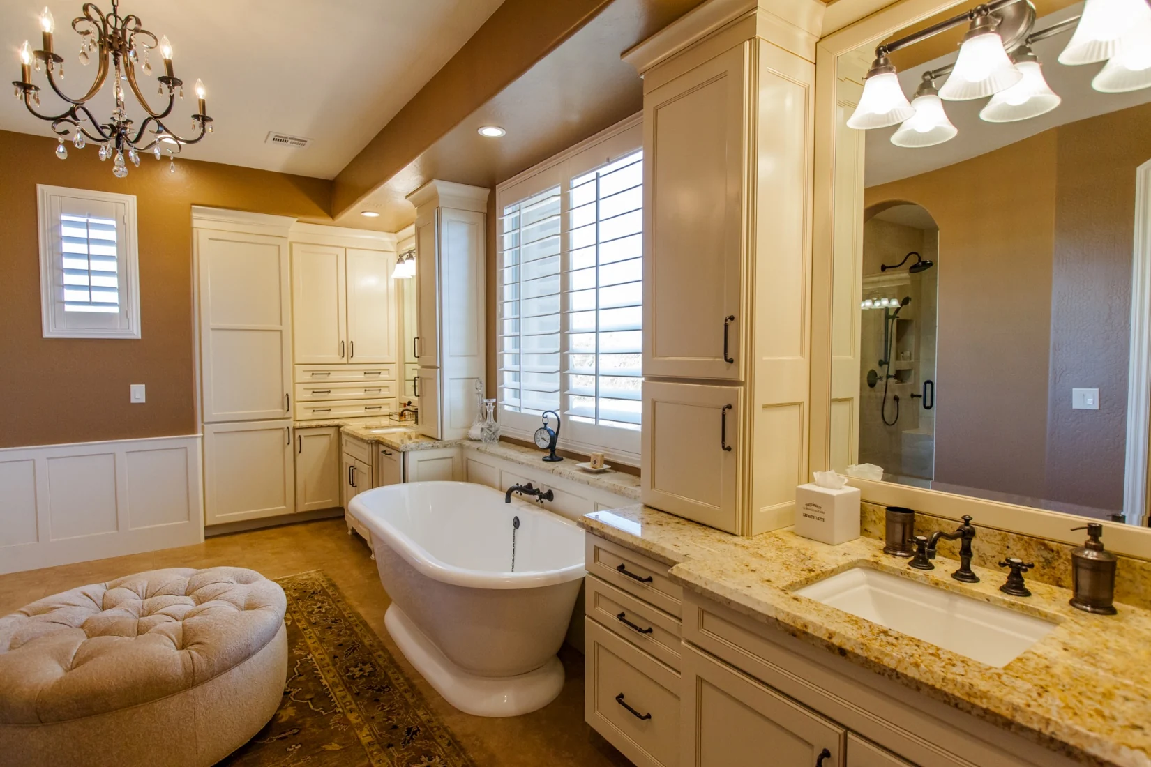 Completed traditional Scottsdale bathroom with glazed white cabinetry, freestanding tub, chandelier, and custom vanities