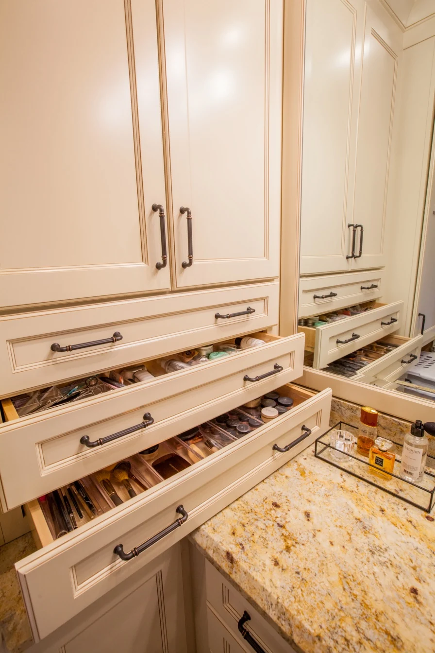 Bathroom cabinet drawers open to show shallow compartments for organizing grooming items