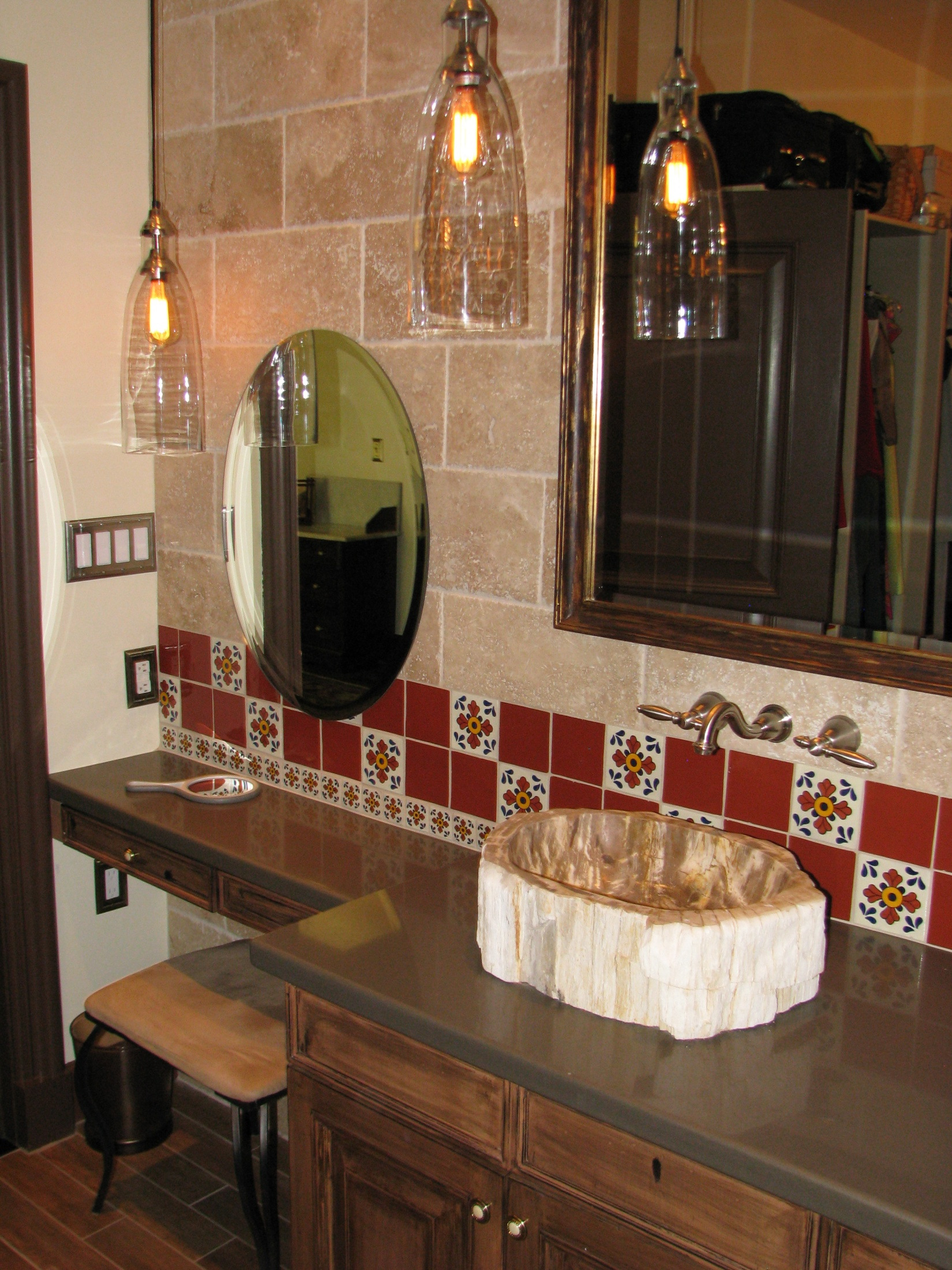 Petrified wood vessel sinks on quartz counters above refinished bathroom cabinetry
