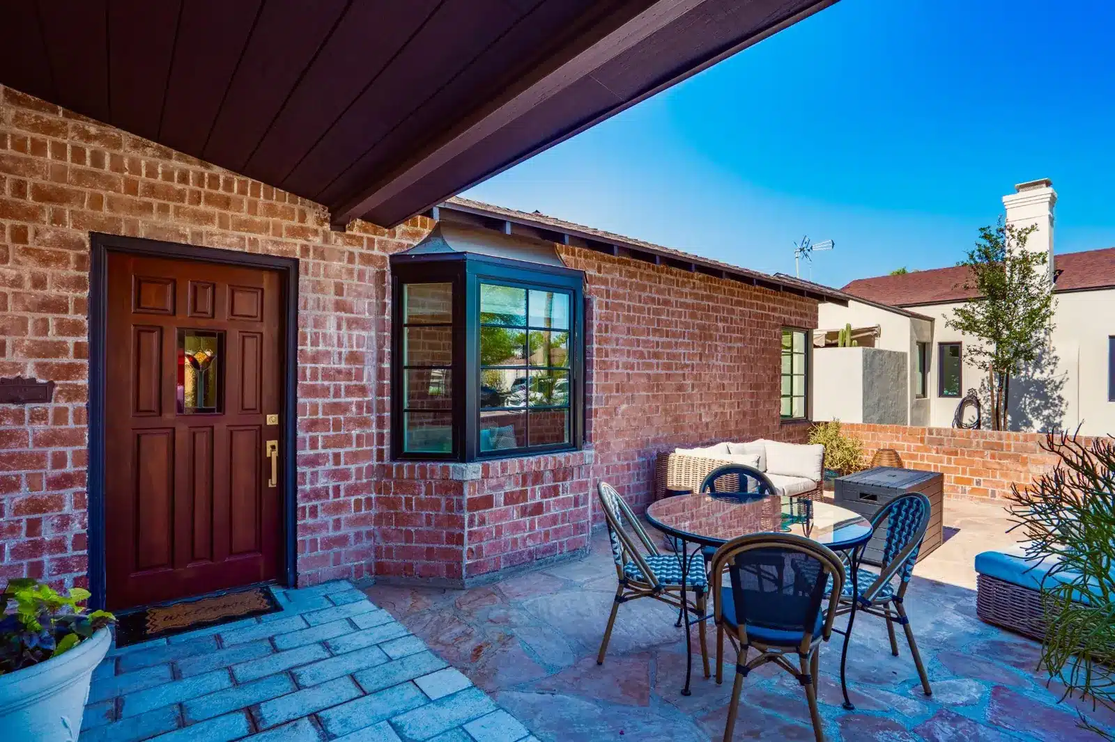 Restored brick front patio, rebuilt bay window, and original stained-glass entry door at a 1935 Willo home