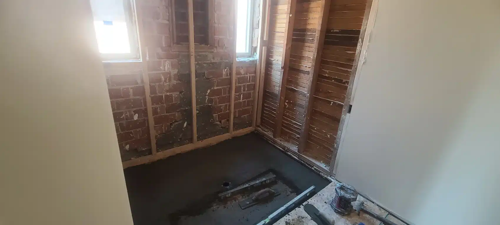 Construction view showing recessed shower floor framing below the bathroom floor