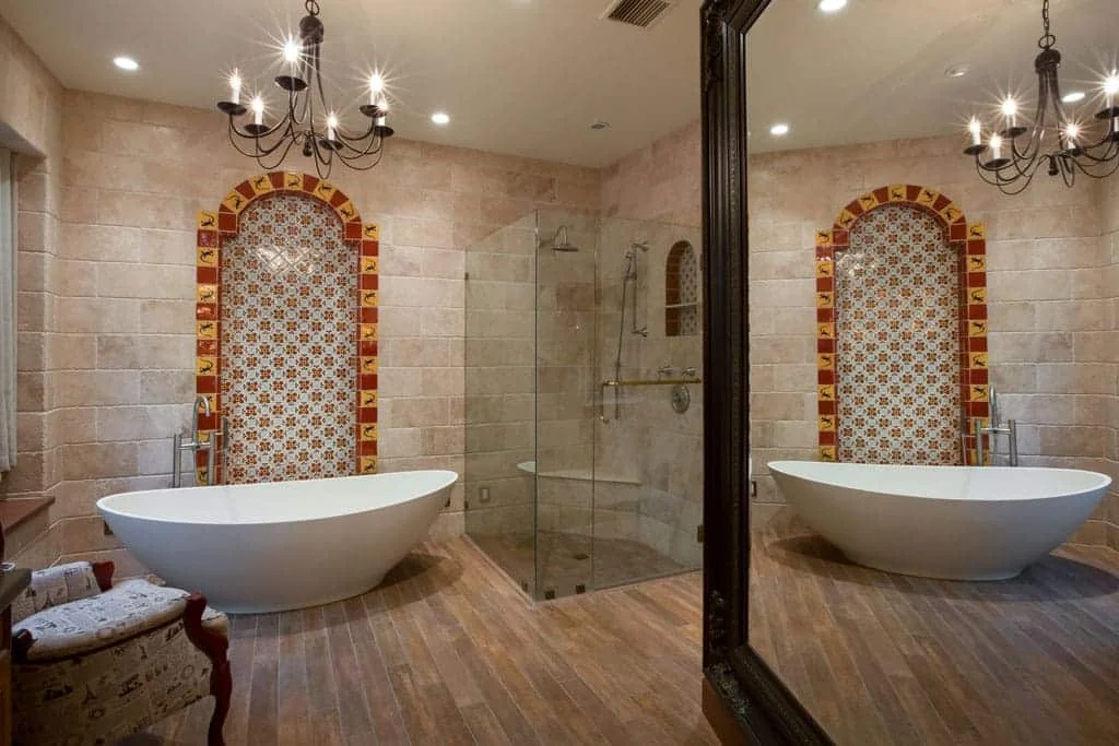Spanish Colonial bathroom remodel in Willo Phoenix with a freestanding tub, patterned tile alcove, travertine walls, and a full-height mirror