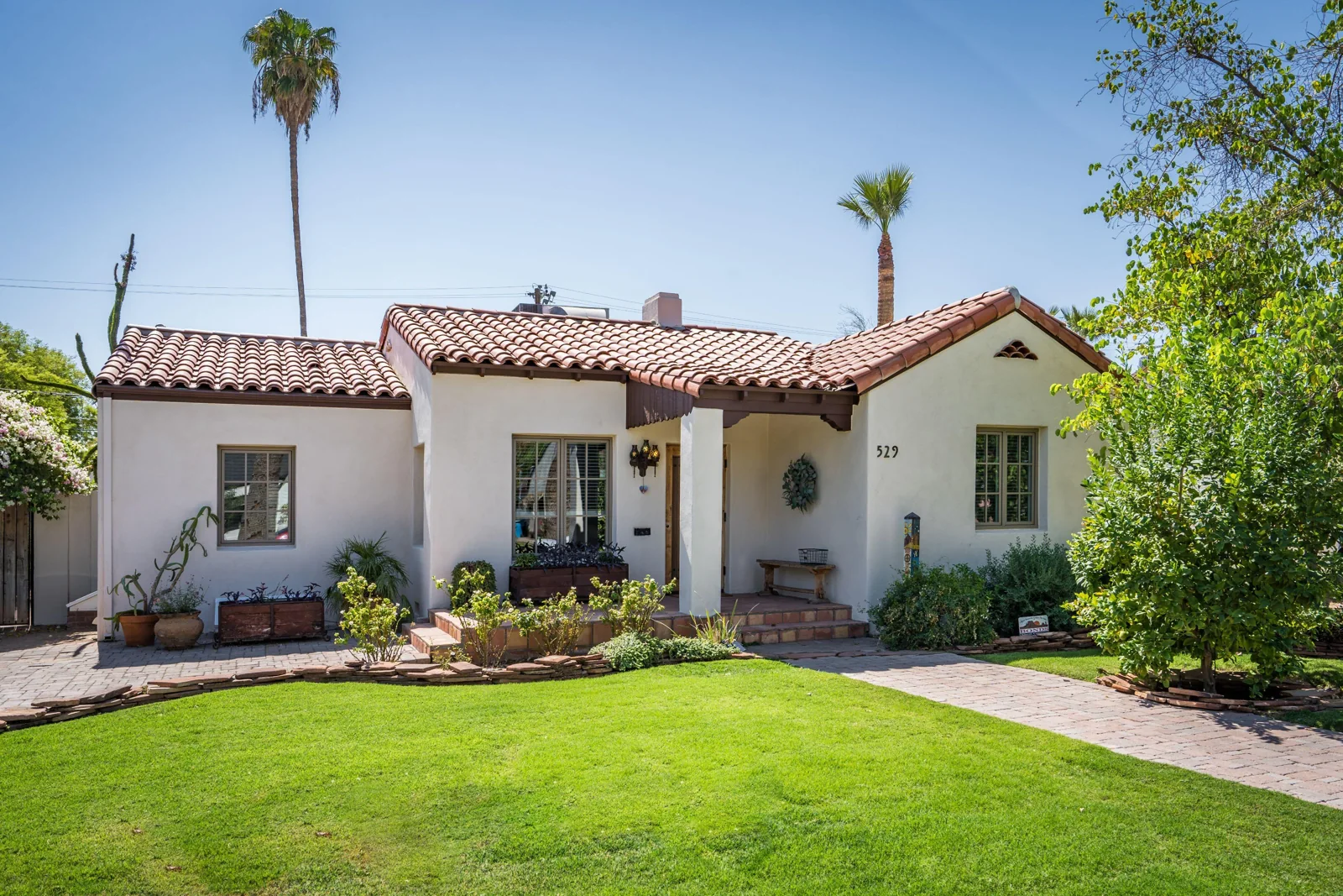Restored Spanish Colonial house in Phoenix with cream stucco, a red tile roof, and a landscaped front lawn