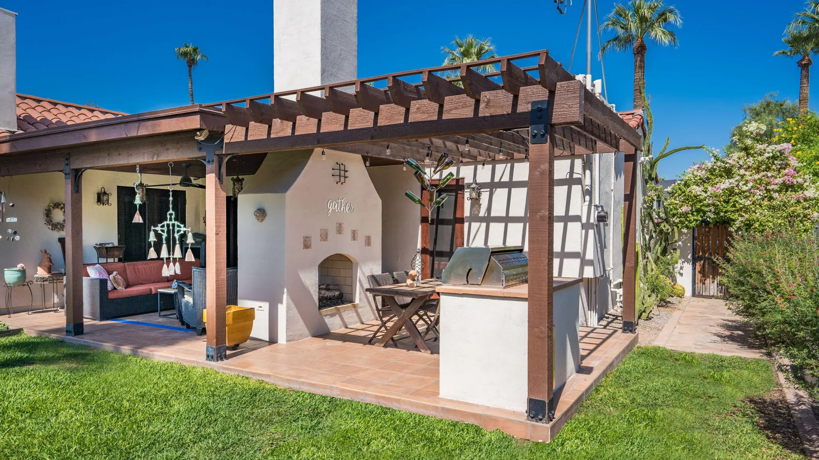 Spanish Colonial exterior remodel in Phoenix’s Willo district with a two-sided fireplace, covered patio, cedar pergola, and outdoor dining