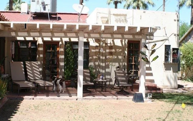 Original open-slat pergola and patio behind the Spanish Colonial home before remodeling