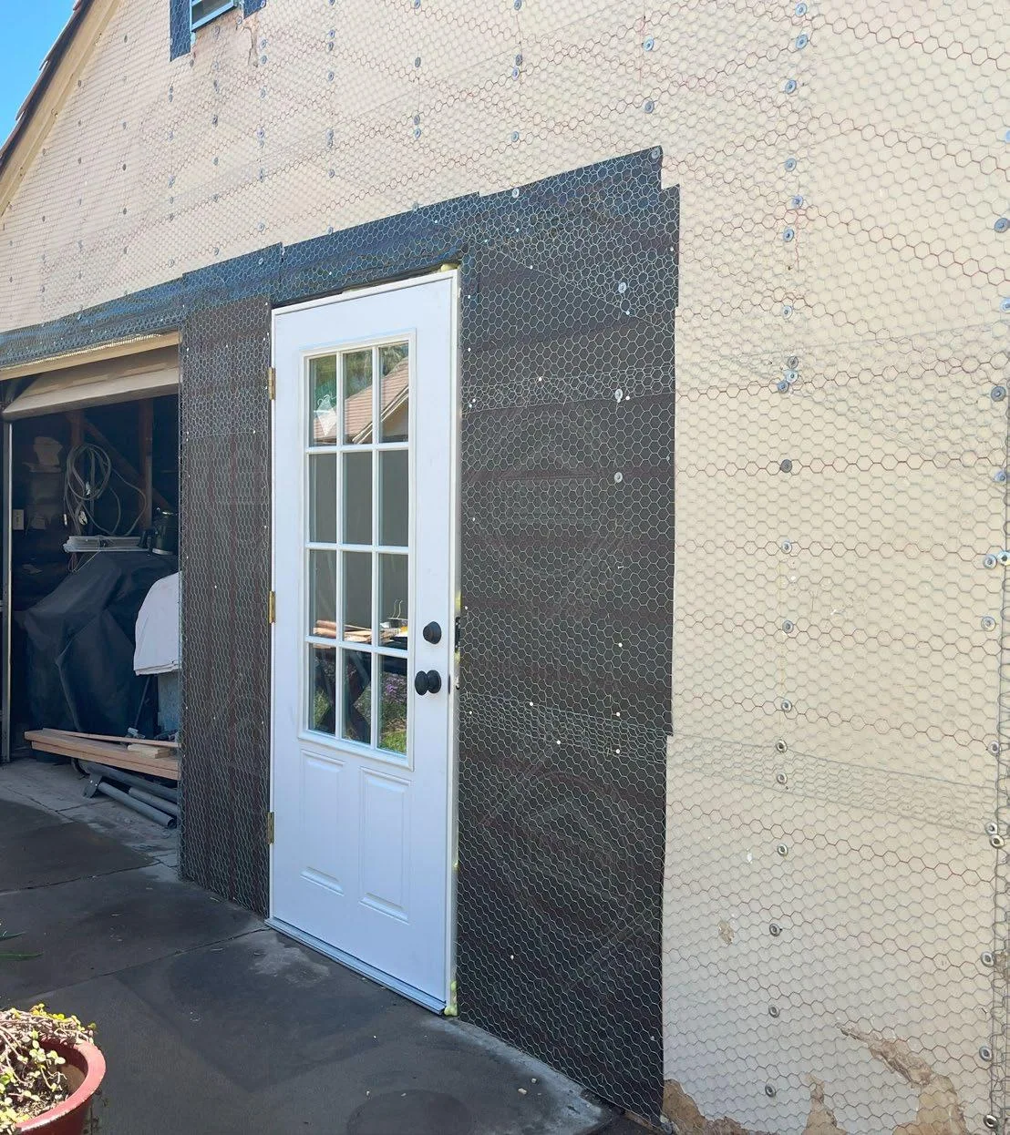New stucco lath installed around an exterior door and window opening
