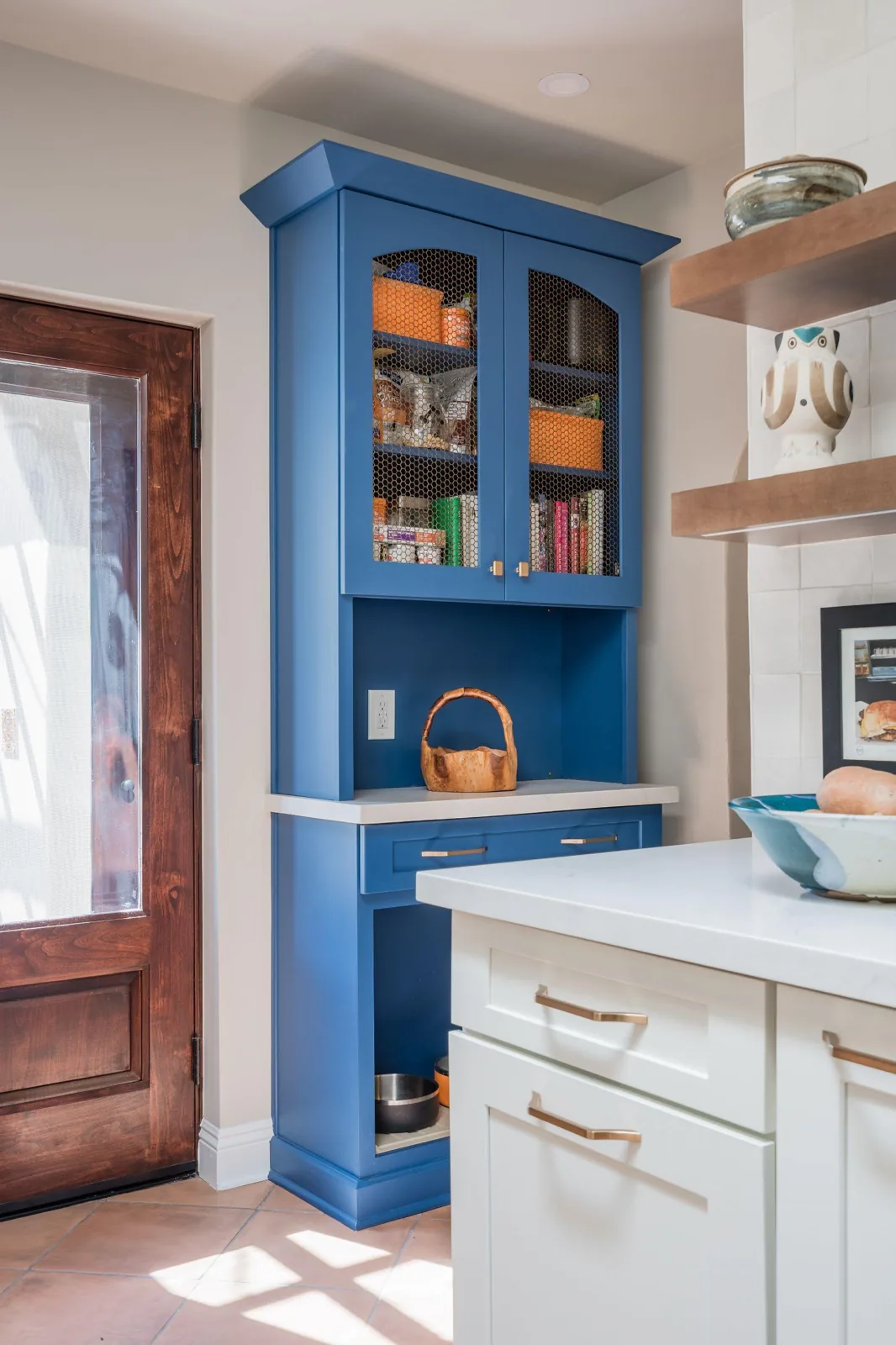 Custom blue kitchen pet cabinet with mesh-front storage, a drawer, and a lower space for dog bowls