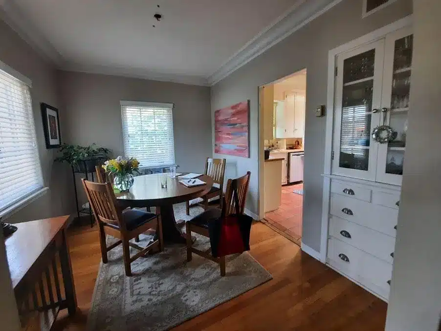 Dining room before renovation with a narrow kitchen doorway and built-in china cabinet