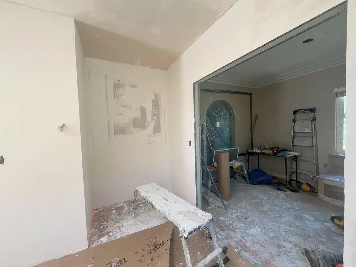Kitchen during construction showing plaster repairs around the widened dining room opening